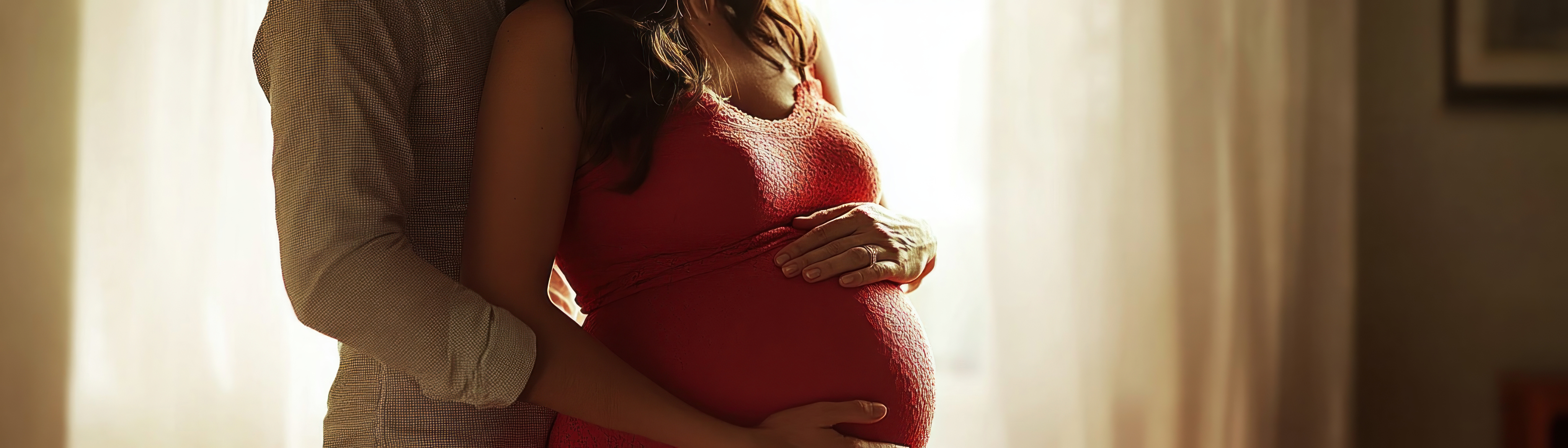 A parent tenderly cradling their pregnant belly