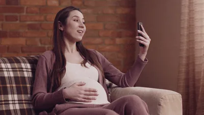 Smiling expectant mother holding her belly