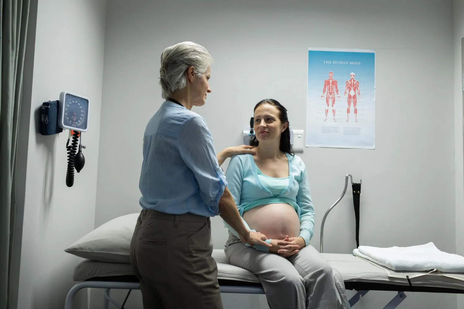 A midwife reassuring a pregnant woman during a clinic consultation